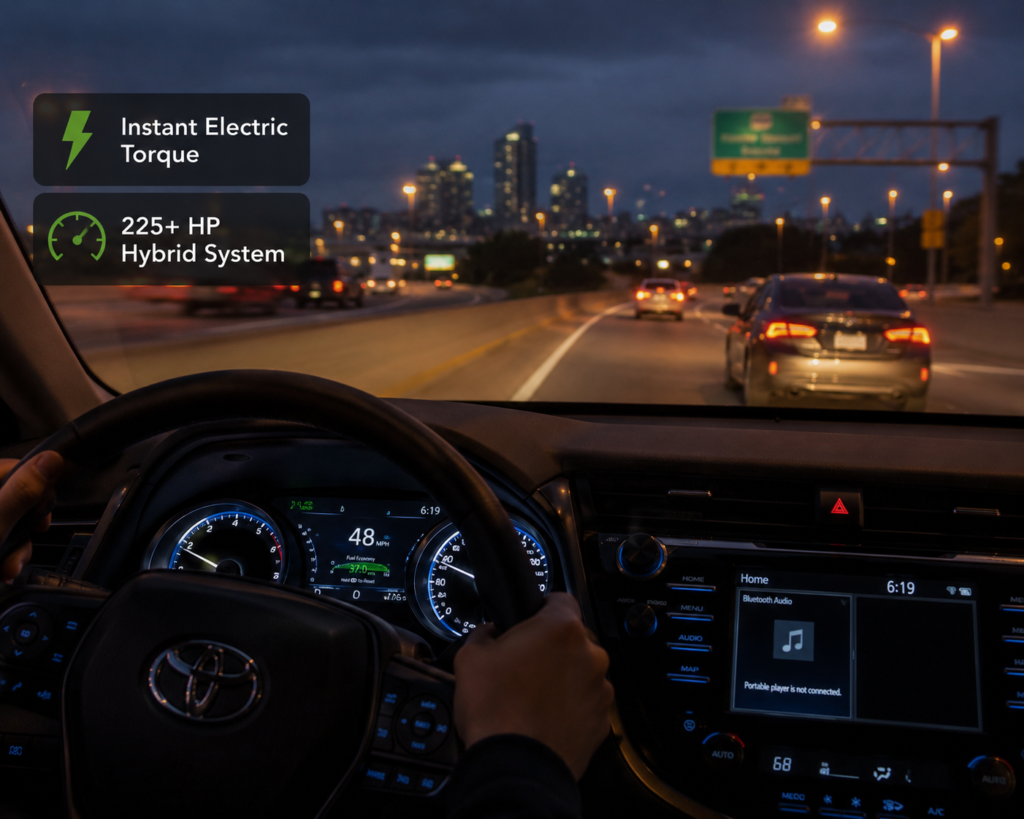 Toyota Camry Hybrid merging onto highway at night with dashboard glow showing instant electric torque and 225+ HP feel