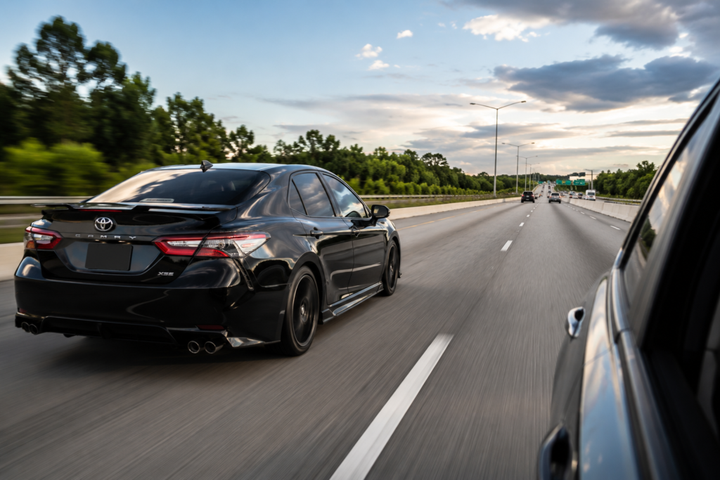 Black Toyota Camry TRD overtaking on highway showing how fast a Toyota Camry can go during real-world driving conditions