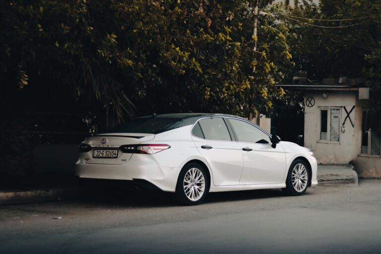 What Type of Car Is a Toyota Camry? White Toyota Camry midsize sedan parked roadside, showing its sleek design.